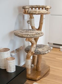 the cat tree is made out of wood and has several scratching pads on top of it