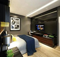 a bedroom with a bed, television and pictures hanging on the wall in front of it