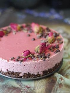 a cake with pink frosting and sprinkles sitting on top of a table