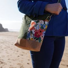 a woman is holding a purse on the beach