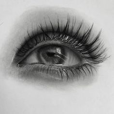 an eye with long lashes is shown in black and white