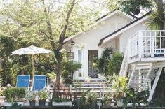 a white house surrounded by trees and plants