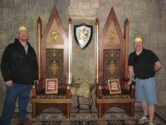 two men standing next to each other in front of chairs with crowns on their heads