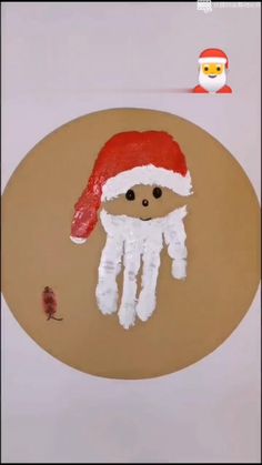 an image of a handprint with a santa hat on it and a small toy in the background