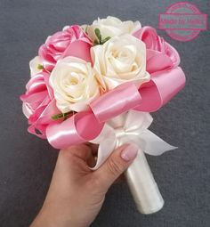 a person holding a pink and white bridal bouquet