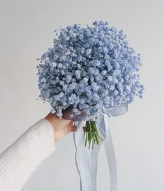 a person holding a bouquet of blue flowers