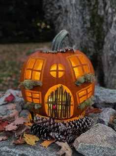 a pumpkin shaped like a house sitting on top of some rocks