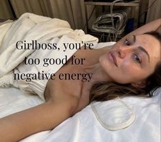 a woman laying on top of a bed under a blanket with the words girlboss, you're too good for negative energy