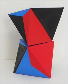 a red, black and blue sculpture sitting on top of a white table