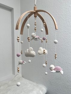 a crocheted mobile with sea animals hanging from it's sides in a white room