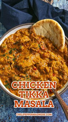 chicken tikka masala in a bowl with a wooden spoon