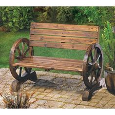 a wooden bench sitting on top of a brick patio next to a potted plant