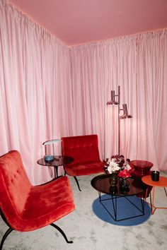 a living room filled with furniture and pink curtains