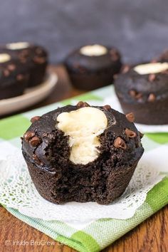 chocolate cupcakes with ice cream in the middle on a green and white napkin