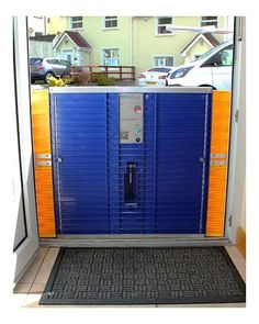 a blue and orange portable toilet in front of a building