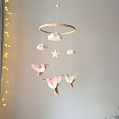 a baby mobile with three little birds hanging from it's sides and stars on the ceiling