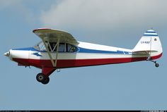 a small red, white and blue plane flying in the sky