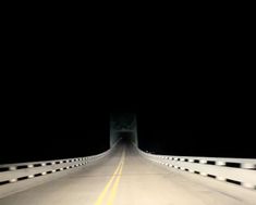 a car driving across a bridge at night