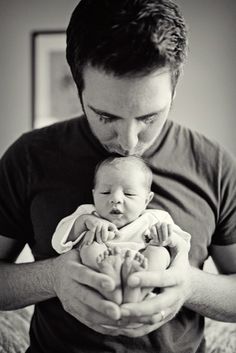 a man holding a baby in his arms and looking at the camera with an instagramr