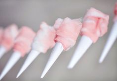 pink and white marshmallows are lined up in a row on a string