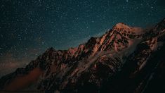 the night sky is filled with stars above snow covered mountains