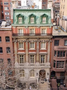 an old building in the city with many windows and balconies on it's sides