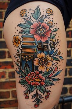 a woman's thigh with flowers and books on it