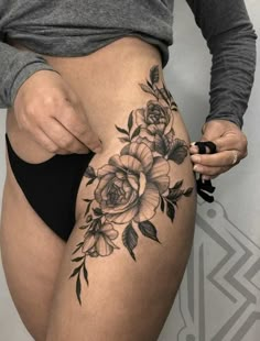 a woman is showing off her thigh with flowers on it