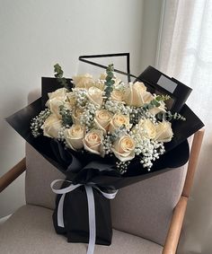 a bouquet of white roses sitting on top of a chair