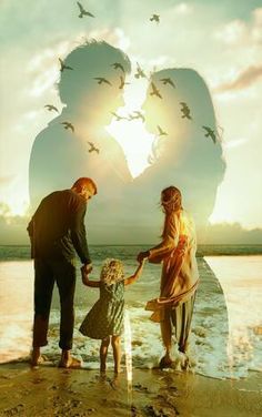 a family holding hands on the beach with birds flying over them and in the background