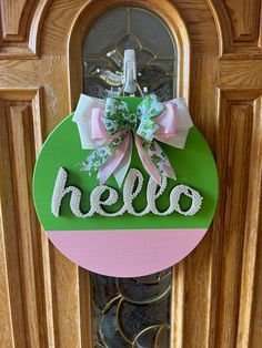 a door hanger with the word hello painted on it in pink, green and white