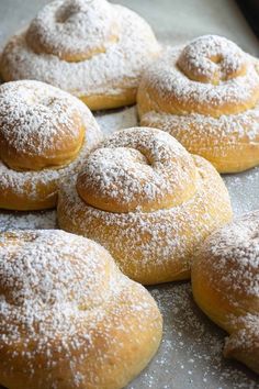 powdered sugar covered donuts on a baking sheet