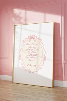 a pink and white photo frame sitting on top of a hard wood floor next to a wall