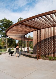 a woman walking her dog in front of a wooden structure