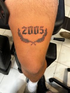 a man with a tattoo on his leg that reads 205 and has laurels around it