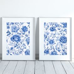 two blue and white flowers are on the wall next to each other in front of a wooden floor