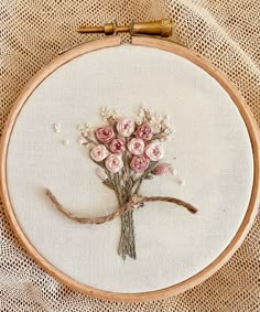 a close up of a embroidery on a piece of cloth with flowers in the middle