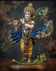 a statue of a hindu god with a flute and peacock tail on it's back