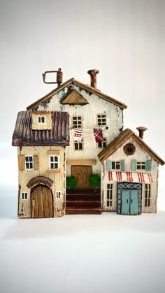 an old fashioned doll house is shown on a white background with blue and red striped awnings