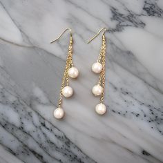 Pretty white shell beads dangle from the chains on these earrings. Tarnish resistant ear hooks and attached shell beads to finish the look. Dangle Earrings Gold, Earrings Pearl, Ear Hook, Etsy Earrings Dangle, Gold Earrings Dangle, Shell Beads, Beaded Dangles, Earrings Gold, Pearl Jewelry