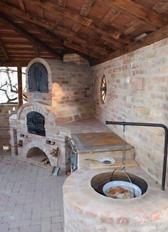 an outdoor kitchen with stone ovens and brick walls