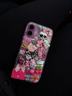 a cell phone case with many different items on the front and back cover, all covered in pink