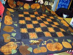 a quilted blanket with pumpkins and leaves on it