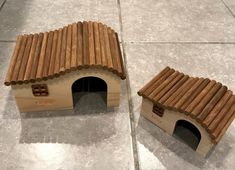 two dog houses made out of wooden sticks on the floor, one is shaped like a house