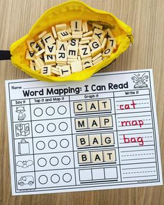 a yellow bag filled with letters and words next to a printable word map on a table