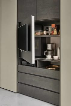 an entertainment center with a flat screen tv and coffee maker