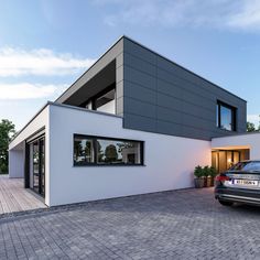 a car is parked in front of a modern house that has been designed to look like it's from the outside