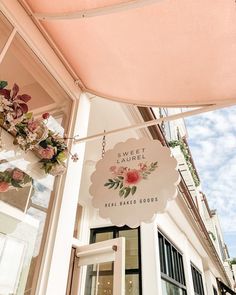 a sign hanging from the side of a building that says sweet shop real baked goods