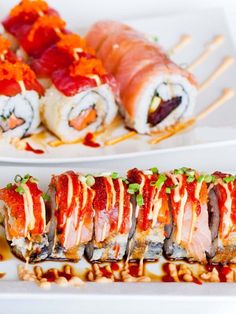 sushi rolls with sauce and garnishes on white plates