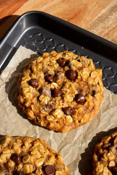 cookies with chocolate chips and oatmeal sitting on top of a cookie sheet